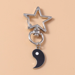 Détail d'un fermoir en métal en forme d'étoile avec pendentif Yin Yang sur fond orange