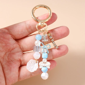 Porte-clés perles à la mode avec nœud bleu, perles, coquillages et chaîne en strass
