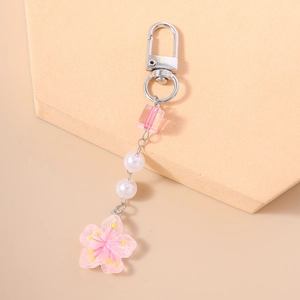 Close-up of pink cherry blossom resin pendant with white pearls and silver lobster clasp