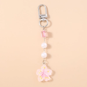 Detail of pink acrylic cherry blossom pendant with white pearls and silver lobster clasp