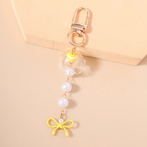 Détail d'un porte-clés perlé avec anneau doré en D et nœud en fil jaune élégant