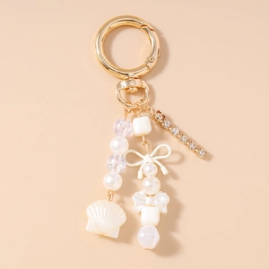 Détail du porte-clés perlé avec strass, perles et nœud coquille sur chaîne dorée