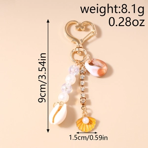 Détail d'un porte-clés à la mode avec perles, breloques coquillages et mesures