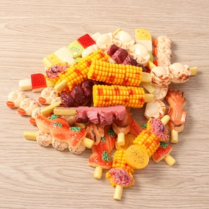 Detailed close-up of realistic resin food charms including grilled skewers and fruit
