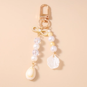 Detail of beaded keychain with pearls, acrylic shell charms and gold lobster clasp