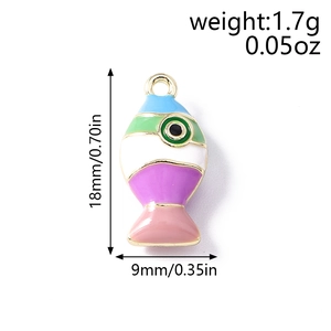 Macro-opname van kleine kleurrijke emaille vis hanger met vergulding toont maat 18mm bij 9mm