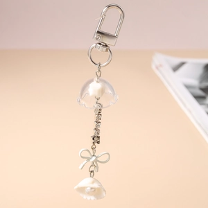 Détail du porte-clés muguet et coquillage avec chaîne en strass et nœud élégant