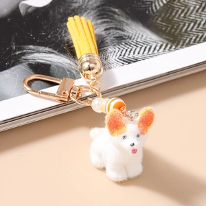 Détail d'un porte-clés Corgi blanc floqué avec pompon jaune et fermoir mousqueton doré