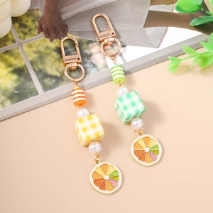Sweet pearl beaded keychain with checkered cubes and citrus slices in orange and green
