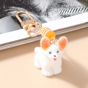 Détail d'un porte-clés chien en peluche blanche avec des oreilles orange vif
