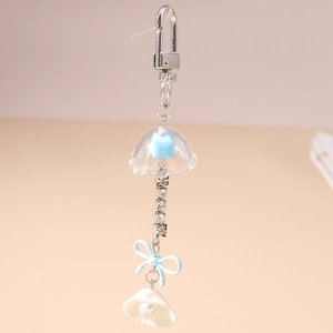 Détail du porte-clés carillon méduse avec nœud bleu et pendentif en nacre de coquillage