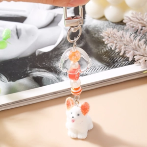 Gros plan d'un mignon porte-clés corgi en peluche avec clochette et perles colorées