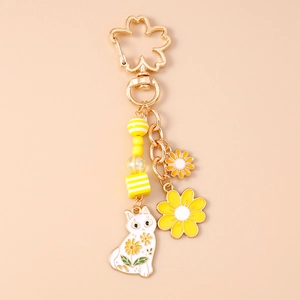 Detailansicht der gelben Gänseblümchen-Schlüsselkette mit Katze und Kirschblütenhaken