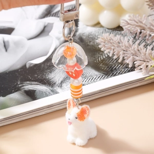 Détail d'un joli porte-clés Corgi avec chien en peluche, perles et crochet en métal argenté