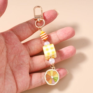 Detail of beaded keychain featuring a lemon slice charm and checkered patterns
