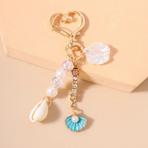 Détails du porte-clés mode avec perles, coquillages naturels et chaînes en strass