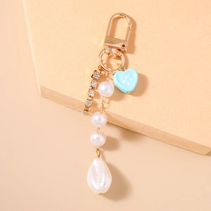 Dettaglio portachiavi di perle con catena di strass e ciondolo a cuore azzurro