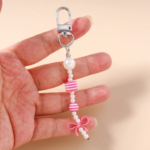 Detailed close-up of pink and white beaded keychain with sweet resin bow and pearls