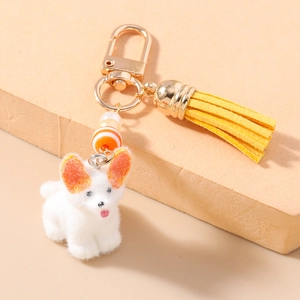 Détail du porte-clés chien en peluche avec fermoir doré, pompon jaune et perles de nacre