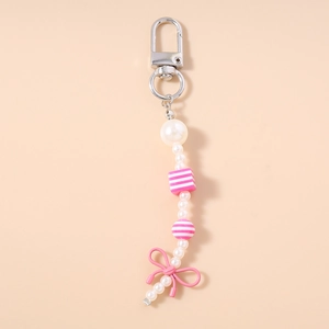 Detailed view of pearl beaded keychain with pink bow charm and striped resin beads