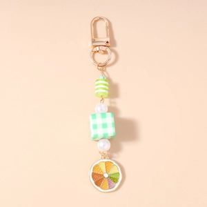 Detail of sweet pearl beaded keychain with green plaid cube and lemon slice charm