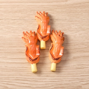 Close-up of resin simulated grilled squid skewers with realistic charred textures