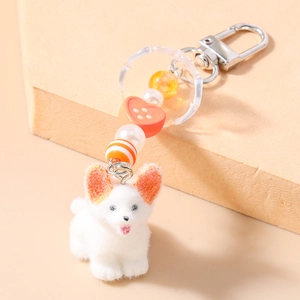 Détail d'un porte-clés Corgi blanc floqué avec perle en cœur orange et fausses perles