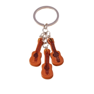 Creative music themed guitar keychain with three orange guitar pendants on white background