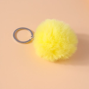 Close-up of fluffy bright yellow 8cm faux fur pompom keychain with silver metal ring
