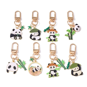 Lot de huit porte-clés panda en émail avec finition dorée sur fond blanc immaculé