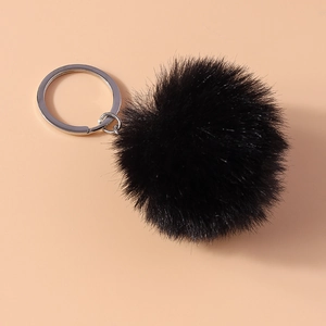 Close-up of fluffy black faux fur pompom keychain with a polished silver metal ring