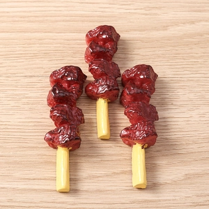 Detailed macro view of three realistic resin barbecue skewers on a wooden background