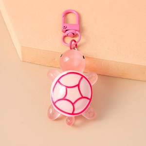 Detail of pink resin turtle keychain with translucent texture and lobster clasp