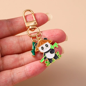 Détail d'un porte-clés panda avec breloque bambou et fermoir mousqueton doré