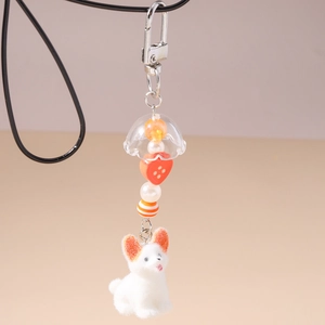 Détail d'un porte-clés chien en peluche avec perles orange et fermoir mousqueton