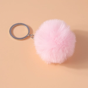 Macro shot of a pink 8cm faux fur pompom keychain with a silver metal clasp for bags