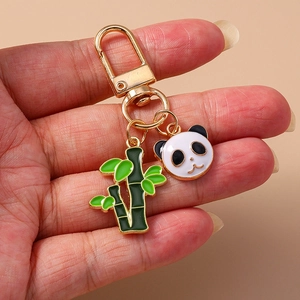Détail d'un porte-clés panda et bambou avec anneau en métal doré et breloques en émail