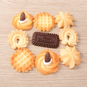 Macro shot of 4Pcs set artificial food charms including waffles and chocolate bars