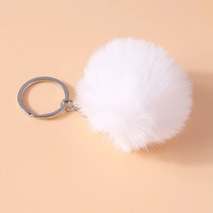 Detailed close-up of a 8cm white faux fur pompom keychain with a silver metal clasp hook