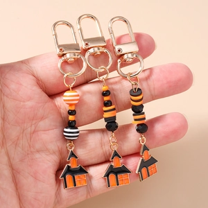 Halloween keychain with orange and black beads, featuring a creative haunted house charm