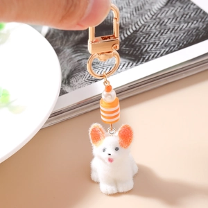 Détail du porte-clés peluche chiot orange et blanc avec fermoir doré et perles