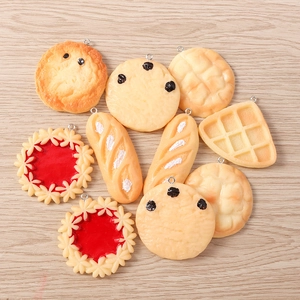 Close-up of realistic resin food charms including waffles and cookies on wood