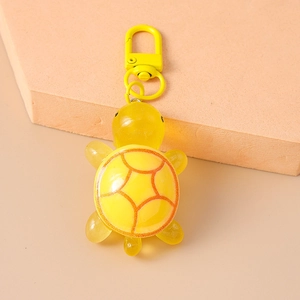 Detail of yellow turtle keychain with matte resin texture and matching metal hook