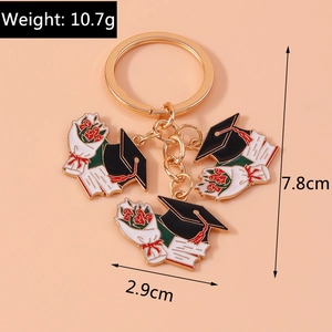 Detail of graduation keychain showing black cap, bouquet, and diploma charms with dimensions