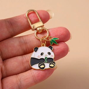 Détail d'un porte-clés panda mignon avec anneau en D doré et petit charme bambou