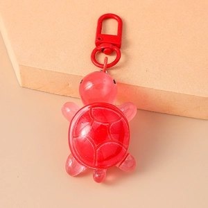 Detail of red translucent turtle keychain with textured shell and red metal clasp