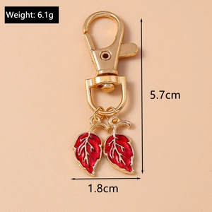 Détail d'un porte-clés feuille rouge avec les dimensions et le poids de l'accessoire
