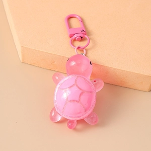 Detail of pink resin turtle keychain with glitter shell pattern and metal lobster clasp