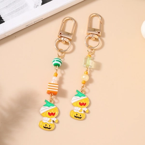 Halloween pumpkin keychain with striped beads and mummy charm in gold finish
