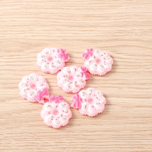 Gros plan de breloques beignets en résine rose avec paillettes et nœuds pour bricolage DIY